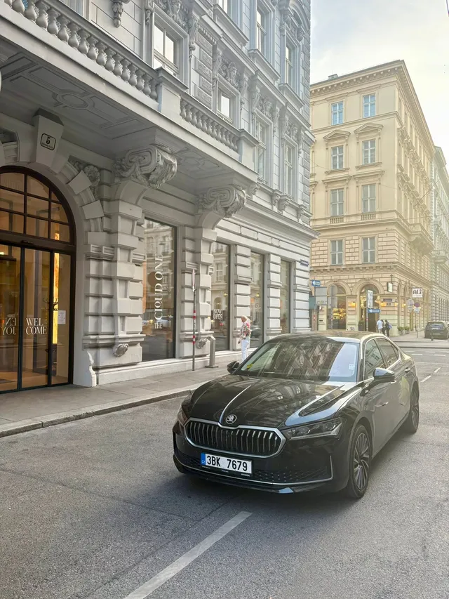 Matt's black Škoda outside a classic building